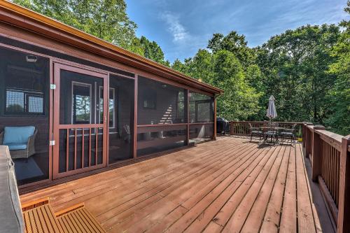 a large wooden deck with a house at Peak-a-Blue Cabin - Watch Movies from Hot Tub, Mountain View, Bigfoot Bunker Game Room, Fire Pit, Oversized Deck, Screened-in Porch in Mineral Bluff