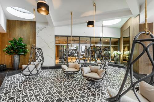 a lobby with two swings and chairs in a building at Hotel Vinifera Wine & Spa 5 Stars Superior in Balatonfüred