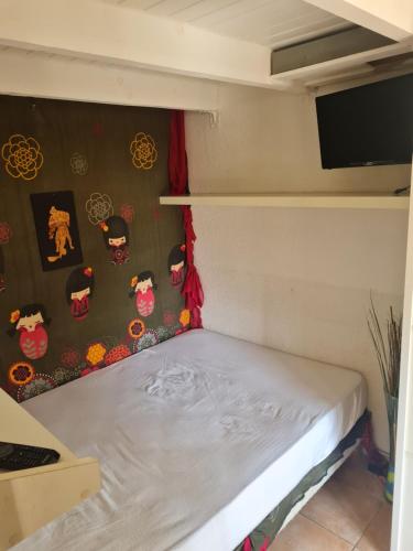 - un petit lit dans une chambre avec un mur recouvert d'autocollants dans l'établissement Appartement cap d agde, au Cap d'Agde