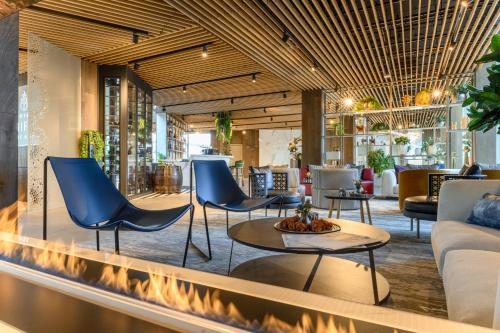 a lobby with blue chairs and a table at Hotel Vinifera Wine & Spa 5 Stars Superior in Balatonfüred