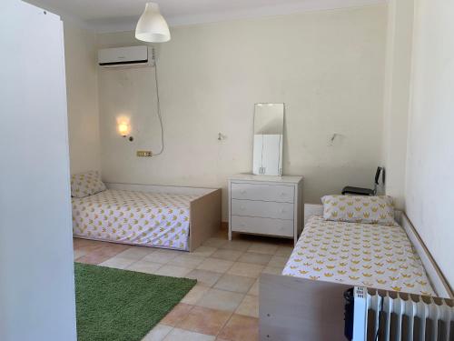1 Schlafzimmer mit 2 Betten, einer Kommode und einem Spiegel in der Unterkunft Perfect family vacation house in King Mariout