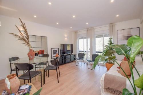 a living room with a glass table and chairs at Amor a mar in Sesimbra