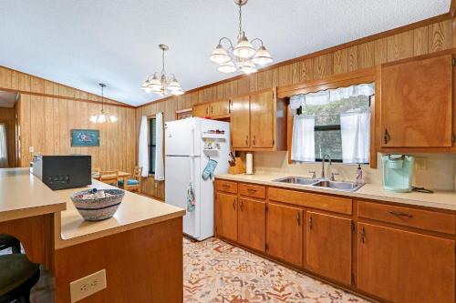 a kitchen with wooden cabinets and a white refrigerator at Miss Lilian's House in Wimberley