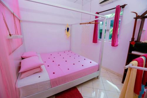a pink bedroom with a bed with pink pillows at Luxury My Villa Bentota 200m Bentota Beach in Bentota