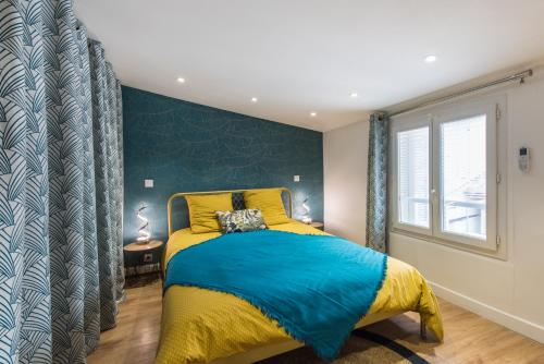 um quarto com uma cama amarela e azul e uma janela em Bel appart rénové - la bohème em Hyères