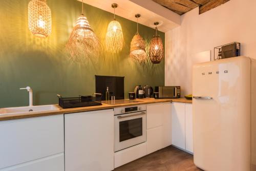 une cuisine avec des armoires blanches et un réfrigérateur blanc dans l'établissement Bel appart rénové - la bohème, à Hyères