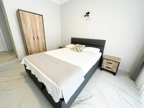 a bedroom with a large bed and a wooden door at Pia Butik Otel Sığacık in İzmir