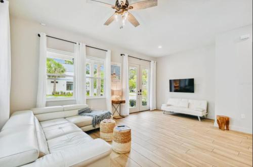 sala de estar con muebles blancos y ventilador de techo en Beach-town Pet-Friendly Downtown Home @ 10 acre Park-629 en Sarasota