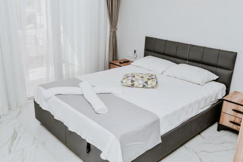 a bedroom with a bed with white sheets and a window at Pia Butik Otel Sığacık in Izmir