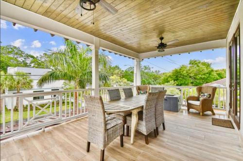 eine Veranda mit einem Holztisch und Stühlen in der Unterkunft Beach-town Pet-Friendly Downtown Home @ 10 acre Park-629 in Sarasota