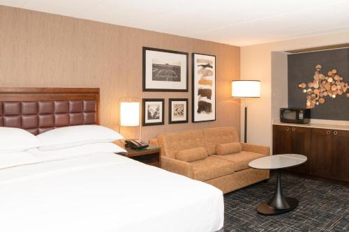 a hotel room with a bed and a couch at Sheraton Ann Arbor Hotel in Ann Arbor
