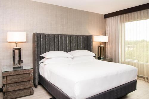 a bedroom with a large white bed and two lamps at Sheraton Ann Arbor Hotel in Ann Arbor
