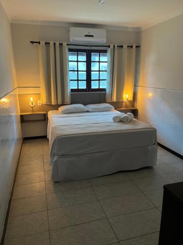 a bedroom with two beds and a window at Pousada La Riviera in Maragogi