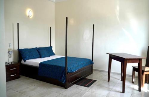 科托努的住宿－Résidence des Amazones Appartement 2，一间卧室配有一张床和一张木桌