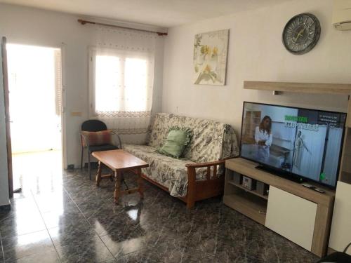 un soggiorno con divano e TV a schermo piatto di bungalows Santa Pola a Gran Alacant