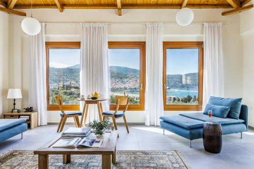 a living room with blue furniture and large windows at Sunshine Pool Villa in Skopelos Town
