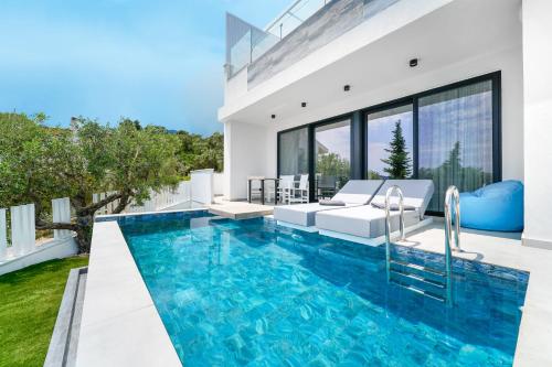 a swimming pool in the backyard of a house at Mythodea Prive Luxury Suites in Chrysi Ammoudia
