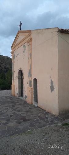 a small church with a cross on top of it at civico 44 in Bova Marina
