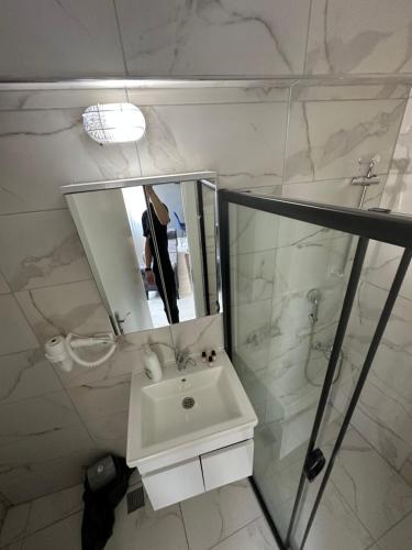 a white bathroom with a sink and a mirror at Arena Resort Otel Kagıthane in Istanbul