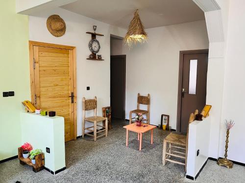 a room with a table and chairs and a clock at sweet house fes in Fès