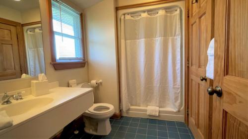 a bathroom with a toilet and a sink and a shower at Pony Island Inn in Ocracoke