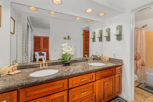 a bathroom with two sinks and a large mirror at Step to beach New Quiet Kiahuna Plantation Remodeled 2 bedroom condo with AC in Koloa
