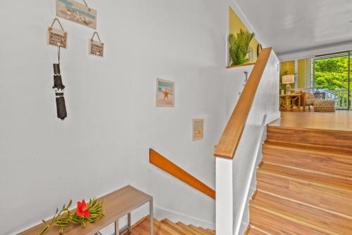 a staircase in a home with white walls and wooden floors at Step to beach New Quiet Kiahuna Plantation Remodeled 2 bedroom condo with AC in Koloa