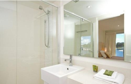 a bathroom with a sink and a shower and a mirror at Driftwood Apartment 6, Noosaville in Noosaville