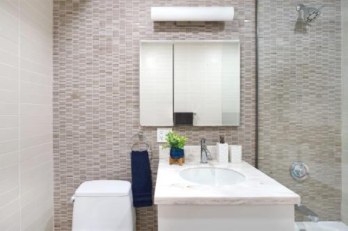 ein Badezimmer mit einem Waschbecken, einem WC und einem Spiegel in der Unterkunft 809-2B New bldg Jr columbus circle Balcony WD in New York