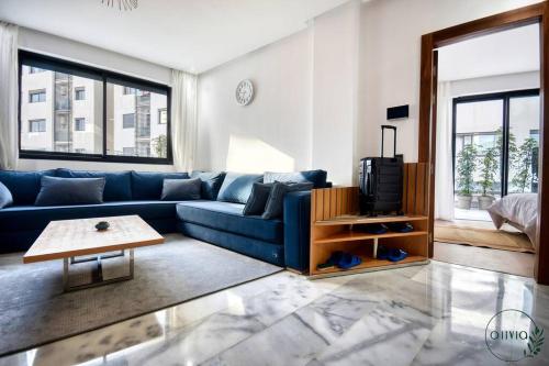 a living room with a blue couch and a table at Olivia By Atlantic in Agadir