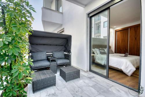 a living room with a chair and a bedroom at Olivia By Atlantic in Agadir