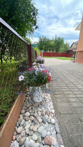 a fence with a bunch of flowers in a flower pot at Japandi apartamentai in Kaunas