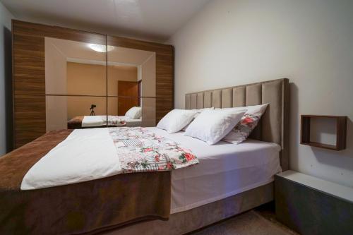 a bedroom with a large bed and a mirror at Apartman Kristijan in Viskovo