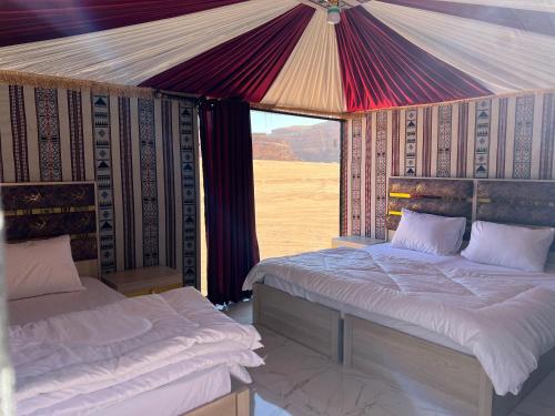 2 łóżka w namiocie z widokiem na pustynię w obiekcie Wadi Rum Sand Camp w mieście Disah