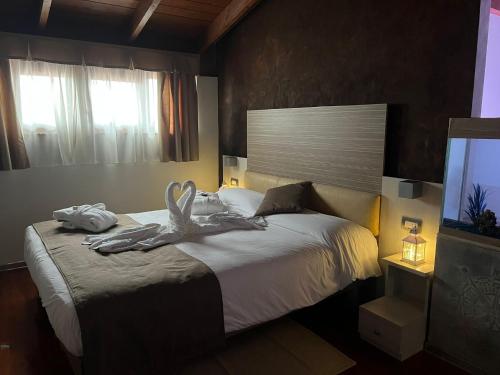 a bedroom with a bed with towels on it at Halanus Hotel And Resort in Alanno