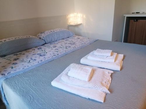 Una cama con toallas encima. en Parco dei Gerani en Formia
