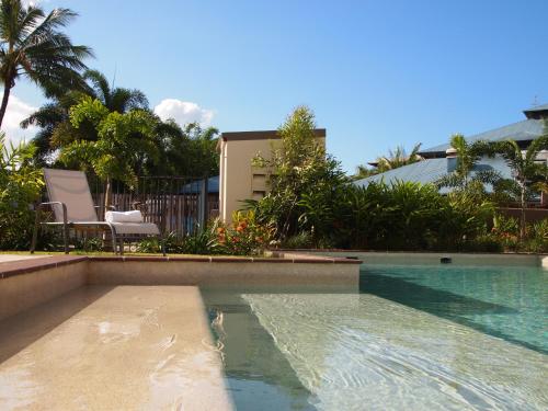 a swimming pool in front of a house at Edge Apartments Cairns in Cairns