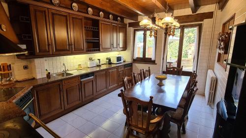 uma cozinha com armários de madeira e uma mesa e cadeiras em Can Vila Rupit em Rupit