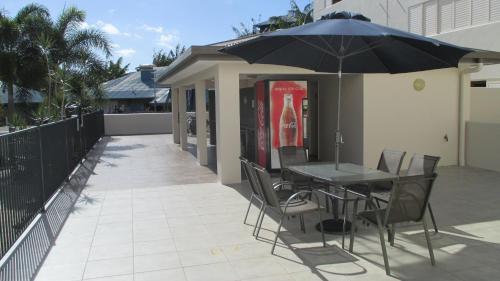 a table and chairs with an umbrella on a patio at Edge Apartments Cairns in Cairns