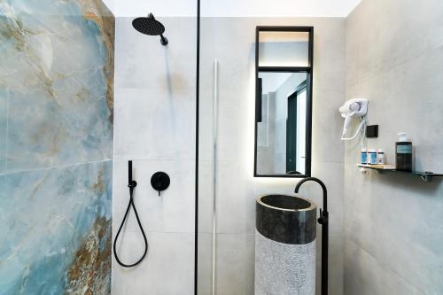 a bathroom with a shower with a glass door at Mythodea Prive Luxury Suites in Chrysi Ammoudia
