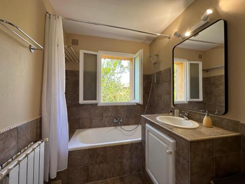 a bathroom with a tub and a sink and a mirror at Villa Marinette in Juan-les-Pins