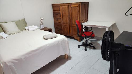 a bedroom with a bed and a desk and a chair at Alojamiento Sol in Tecomán