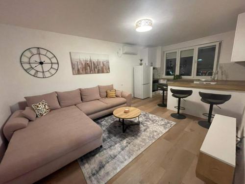 a living room with a couch and a kitchen at Promenada Apartment in Novi Sad