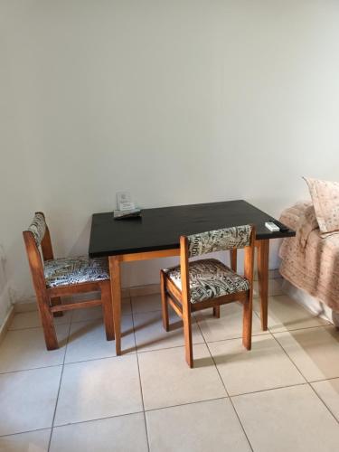 una mesa negra y dos sillas y una mesa y un sofá en Kaedo en Corrientes