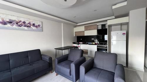 a living room with two couches and a kitchen at The Logo Family Apart in Altınkum