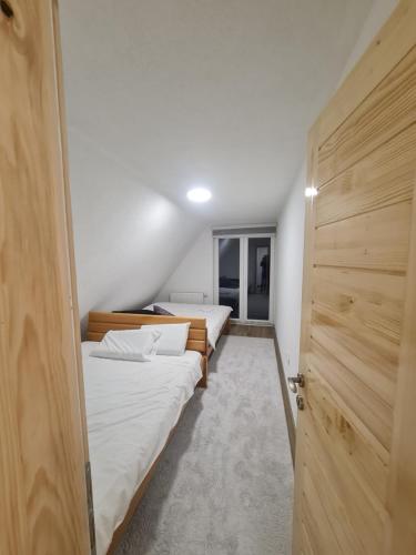 two beds in a room with a door open at Sarajevo NATURE Romanija in Sarajevo