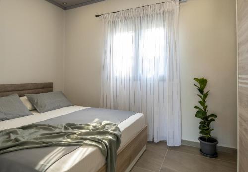 a bedroom with a bed and a window at Morfo Luxury Living in Sikia