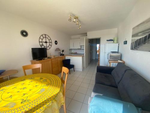 un salon avec un canapé bleu et une table dans l'établissement Les Pêcheurs, à Mimizan