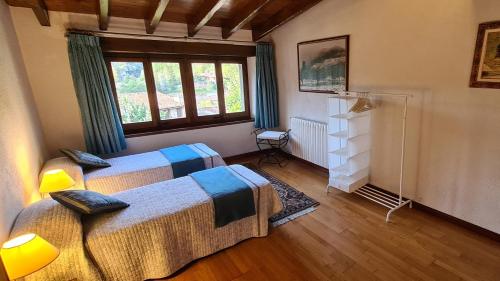 um quarto com 2 camas e uma janela em Can Vila Rupit em Rupit