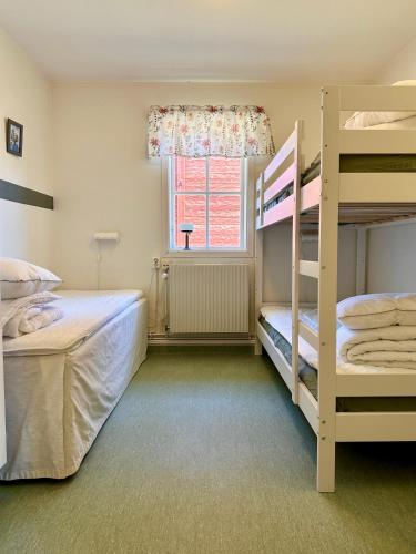 a bedroom with two bunk beds and a window at Valla Vandrarhem in Linköping